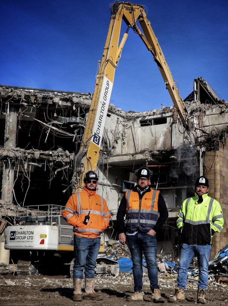 building undergoing demolition with 3 workmen