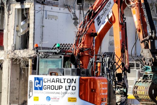 excavator in front of partially demolished building